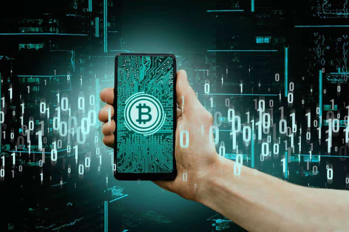 Hand holding a smartphone displaying a Bitcoin symbol over a circuit board, with a digital, futuristic background.